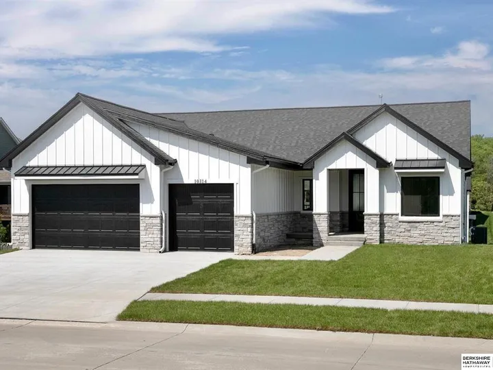 White modern farmhouse with black garage doors