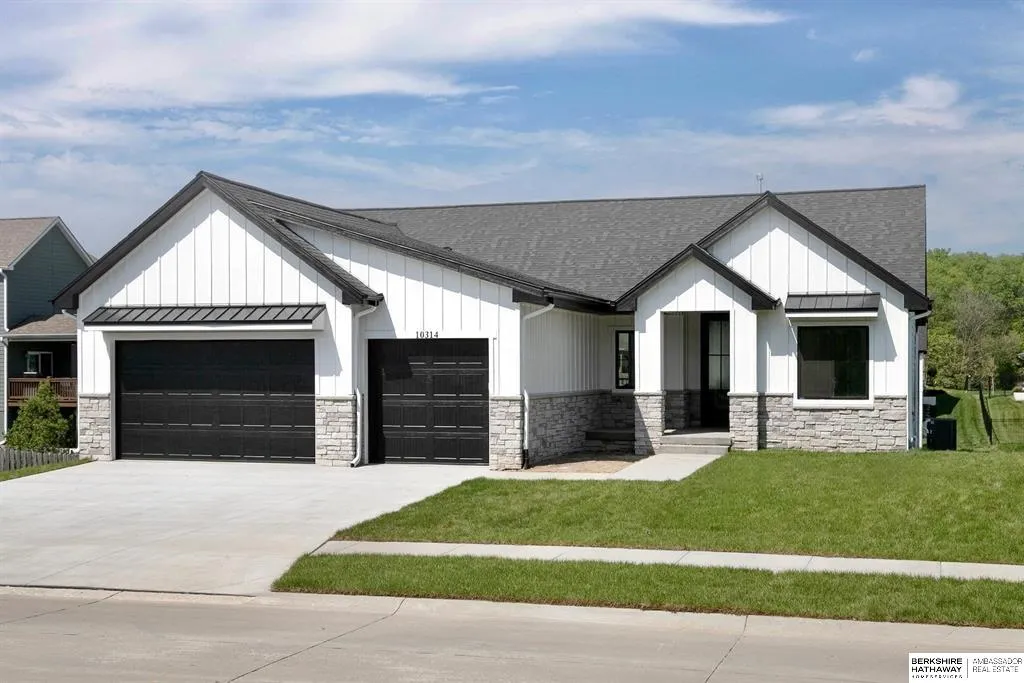 White modern farmhouse with black garage doors